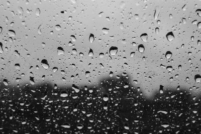 Close-up of wet glass window in rainy season