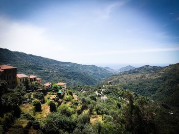 Scenic view of townscape and mountains against sky