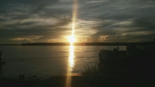 Scenic view of sea against cloudy sky at sunset