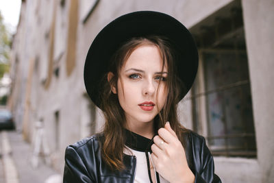 Portrait of young woman wearing black hat