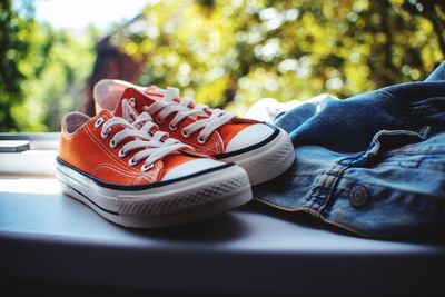 Close-up of shoes and jeans on window