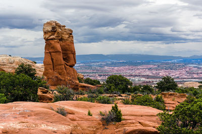 Rock formations on landscape against cloudy sky