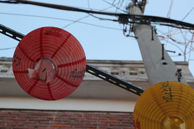 Low angle view of lanterns hanging on pole against building