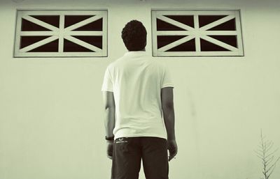 Rear view of woman standing in front of wall