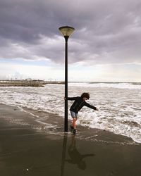 Man standing at beach against sky