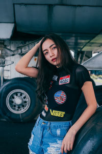 Portrait of beautiful young woman standing against wall