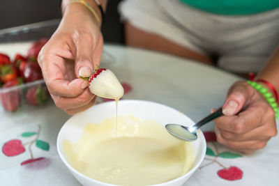 Midsection of man preparing food in bowl on table