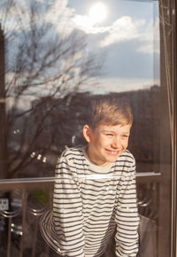 Smiling boy seen through window