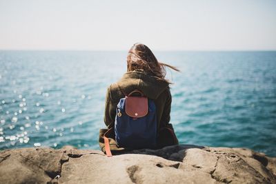 Rear view of woman looking at sea against sky