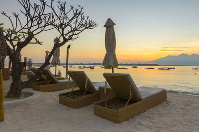 Sculpture by sea against sky during sunset