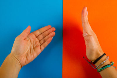 Close-up of hand against blue background