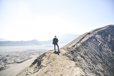 Full length of man standing on mountain against sky