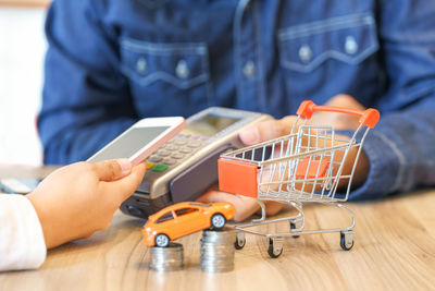 Midsection of man using smart phone at store