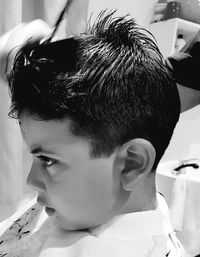 Close-up boy getting haircut in barber shop