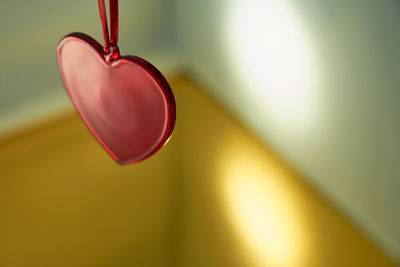 Close-up of heart shape hanging on pink wall