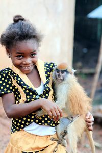 Portrait of happy girl playing with monkey
