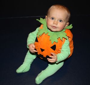 Cute boy playing baby against black background