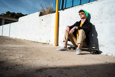 Full length of young woman sitting in sunglasses