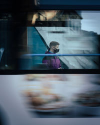 Blurred motion of man seen through bus window