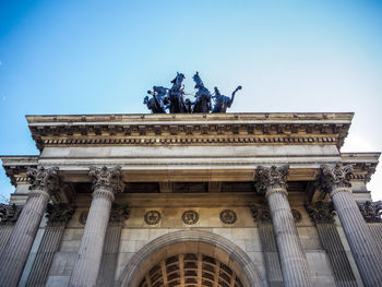 Low angle view of statue against blue sky