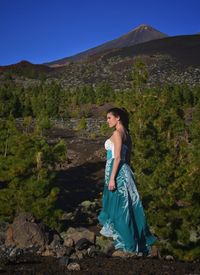 Young woman standing on mountain against clear sky