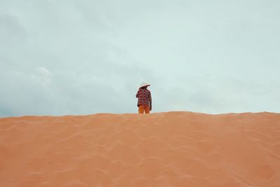 Low angle view of woman standing on sand