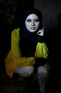 Portrait of young woman sitting outdoors