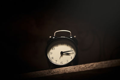 Close-up of pocket watch against black background