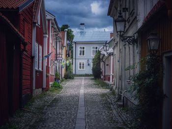 Walkway amidst buildings against sky