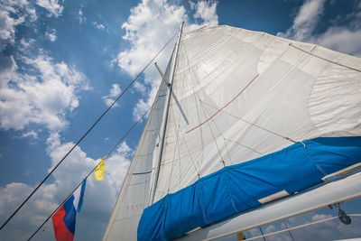 Low angle view of tall ship against blue sky