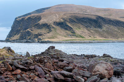 Rocks by sea against sky