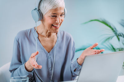 Senior woman using laptop, having video call.