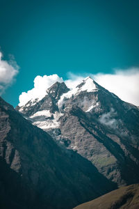 Scenic view of snowcapped mountains against blue sky