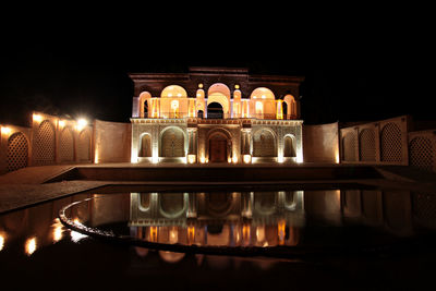 Reflection of illuminated building in lake at night