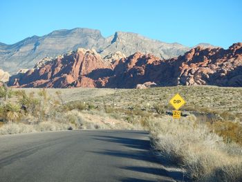 Empty road by rocky mountains in red rock canyon national conservation area