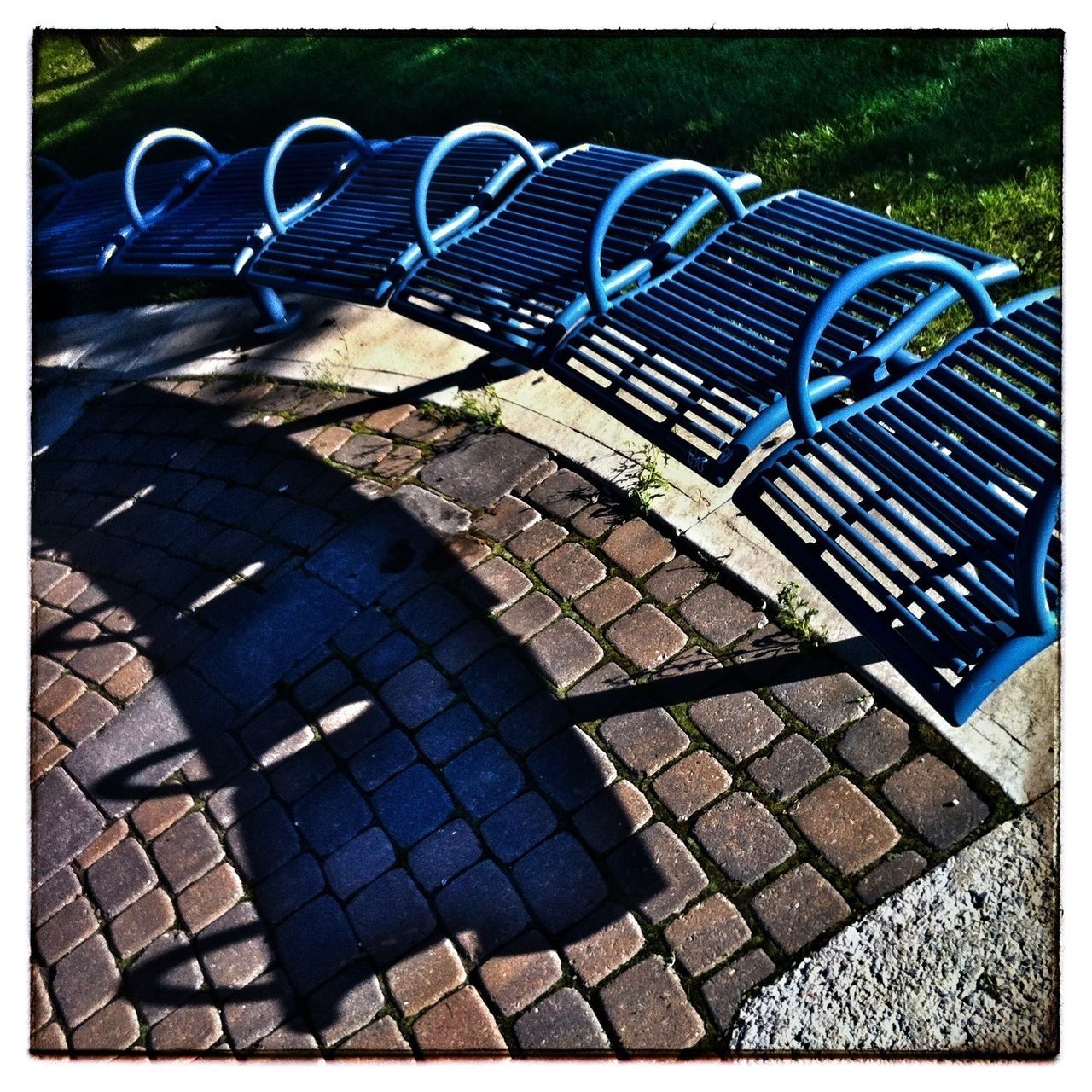 transfer print, auto post production filter, high angle view, cobblestone, shadow, paving stone, low section, sunlight, grass, outdoors, day, street, shoe, pattern, person, sidewalk, footpath, footwear, standing