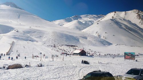 People on snow covered mountain against sky