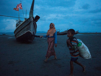 Children standing on boat against sky