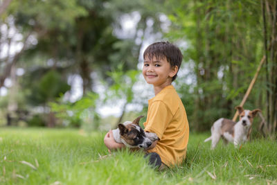 Portrait of boy with dog on grass