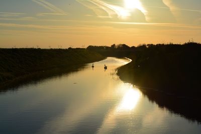 Scenic view of river against sky during sunset