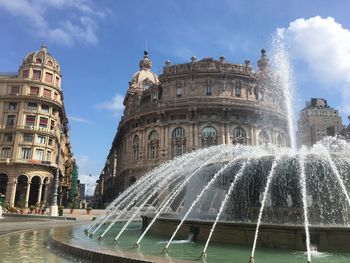 Water fountain against buildings in city