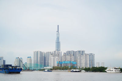 Commercial dock against buildings in city against sky