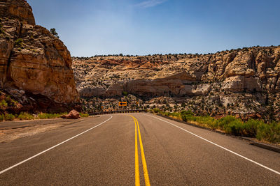 Road leading towards mountains against sky