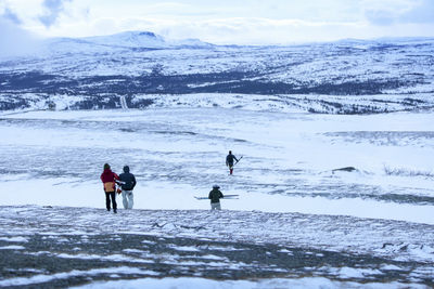 People skiing, rear view