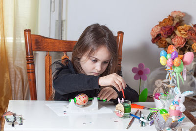 Portrait of happy girl holding table