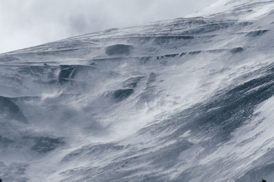 Low angle view of snowcapped mountain against sky