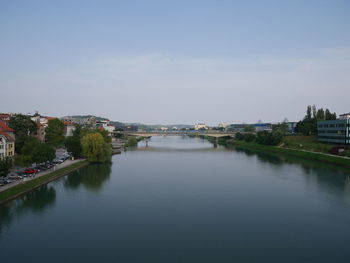 Scenic view of river by buildings against sky