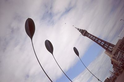 Low angle view of birds flying against cloudy sky