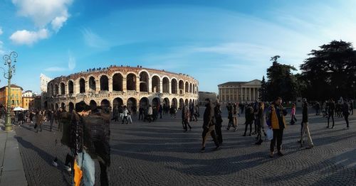 People at historical building against sky