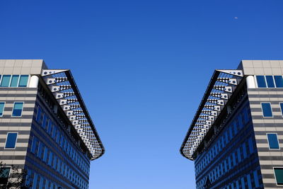 Low angle view of buildings against clear blue sky